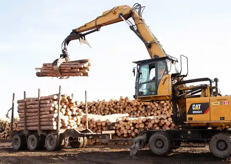 Machinerie forestière manipulant des billots en Ontario dans l’industrie du bois