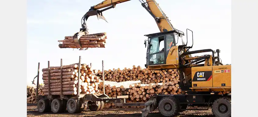 Machinerie forestière manipulant des billots en Ontario dans l’industrie du bois